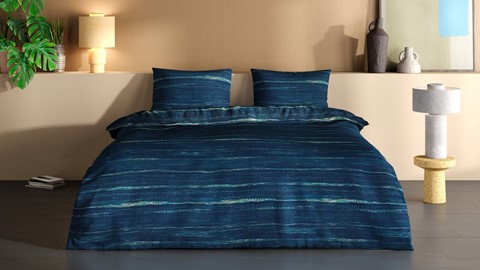 een bed met een blauw dekbed en kussens