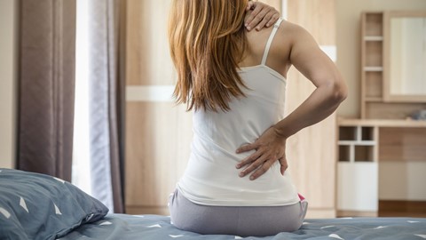 Vrouw met lage rugpijn en schouderklachten